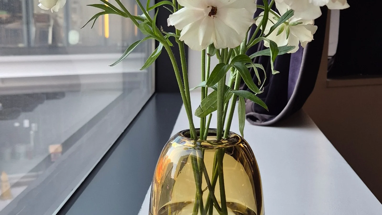 White seasonal flowers by a window at Mahina Vegan Table