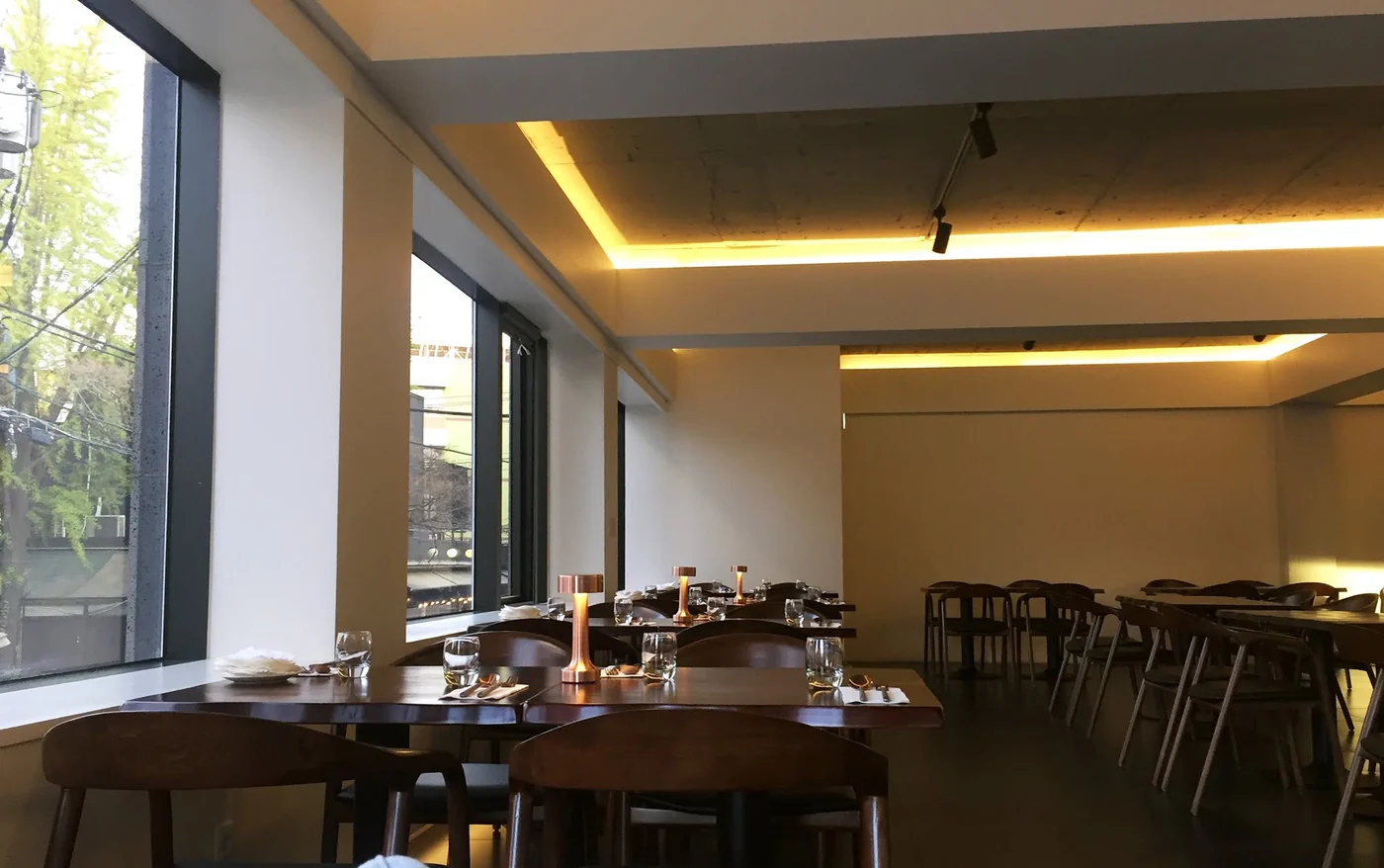 Interior of Mahina Vegan Table with window-side seating and wooden tables