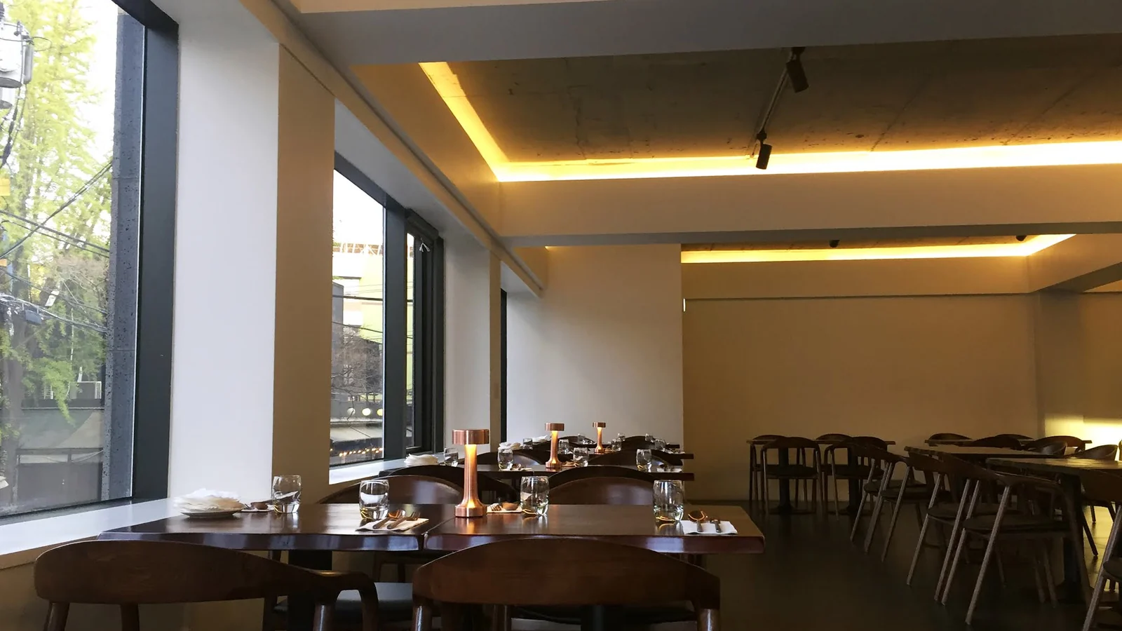 The Mahina Vegan Table interior with windows and wooden tables