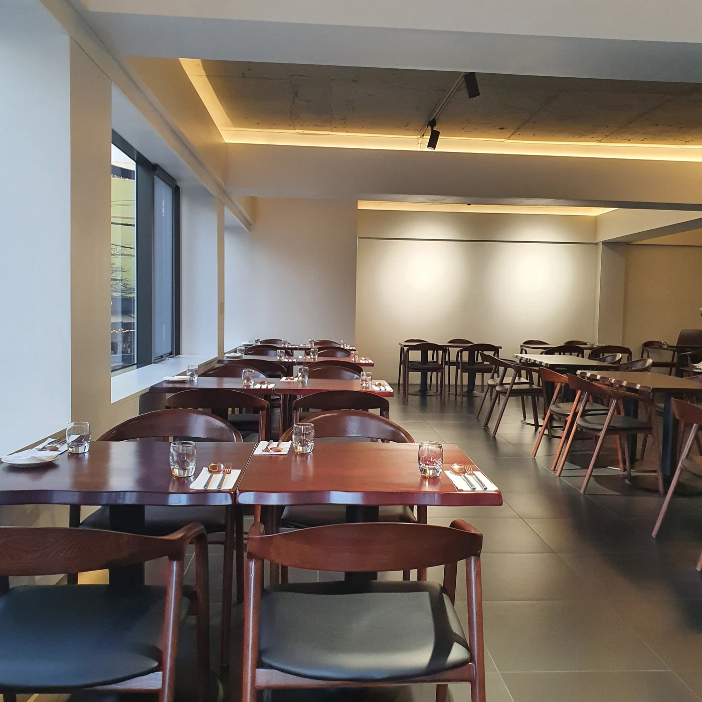 The interior of Mahina Vegan Table with bright windows and wooden tables