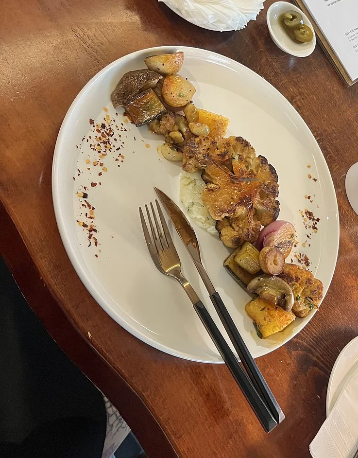 Mahina Vegan Table Cauliflower Steak with a long piece of grilled cauliflower and vegetables