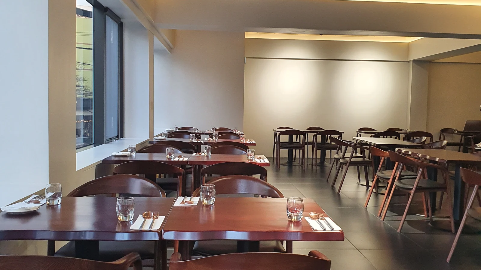 The interior of Mahina Vegan Table with bright windows and wooden tables