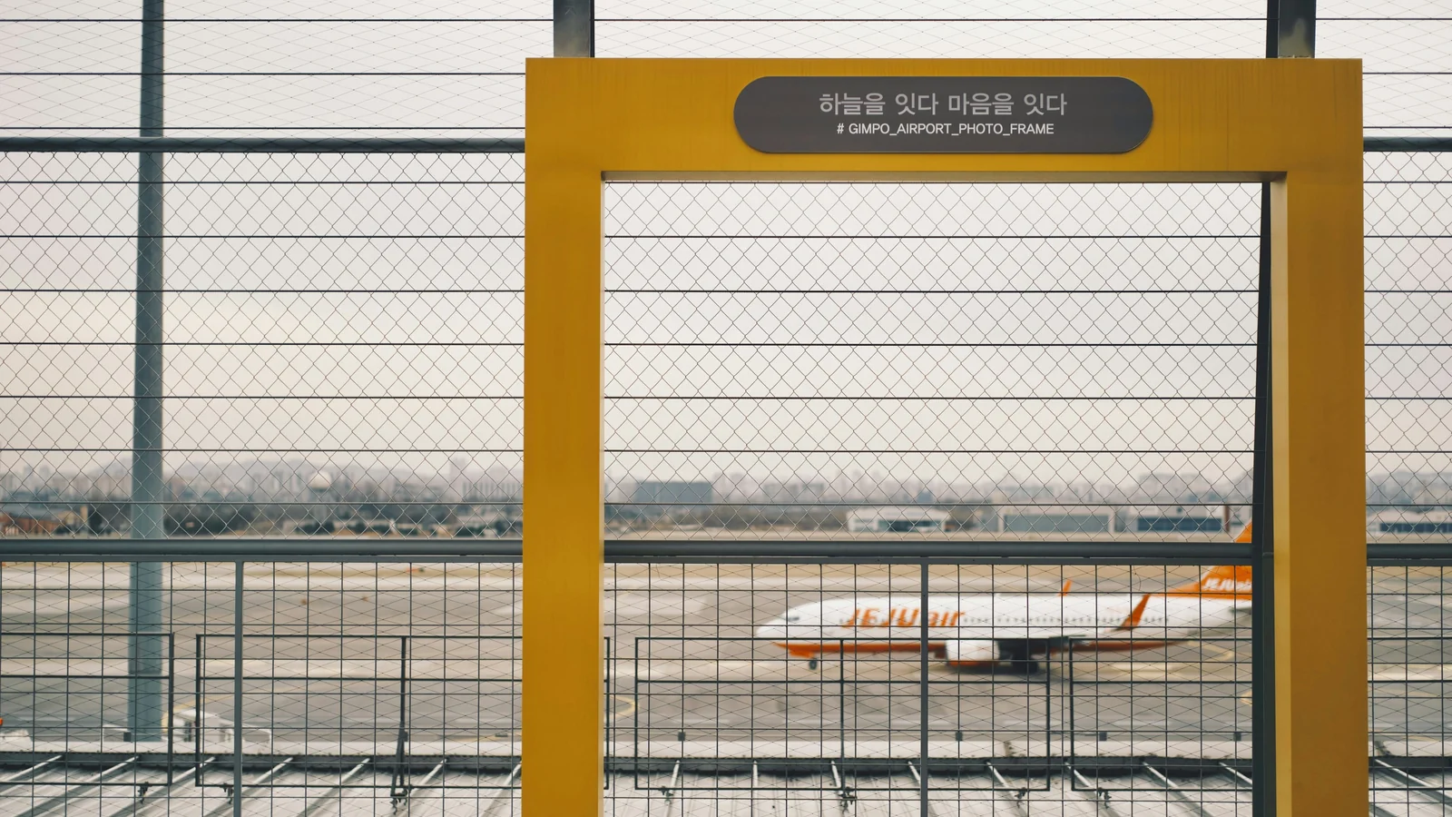 An aircraft seen beyond a gate at Gimpo International Airport