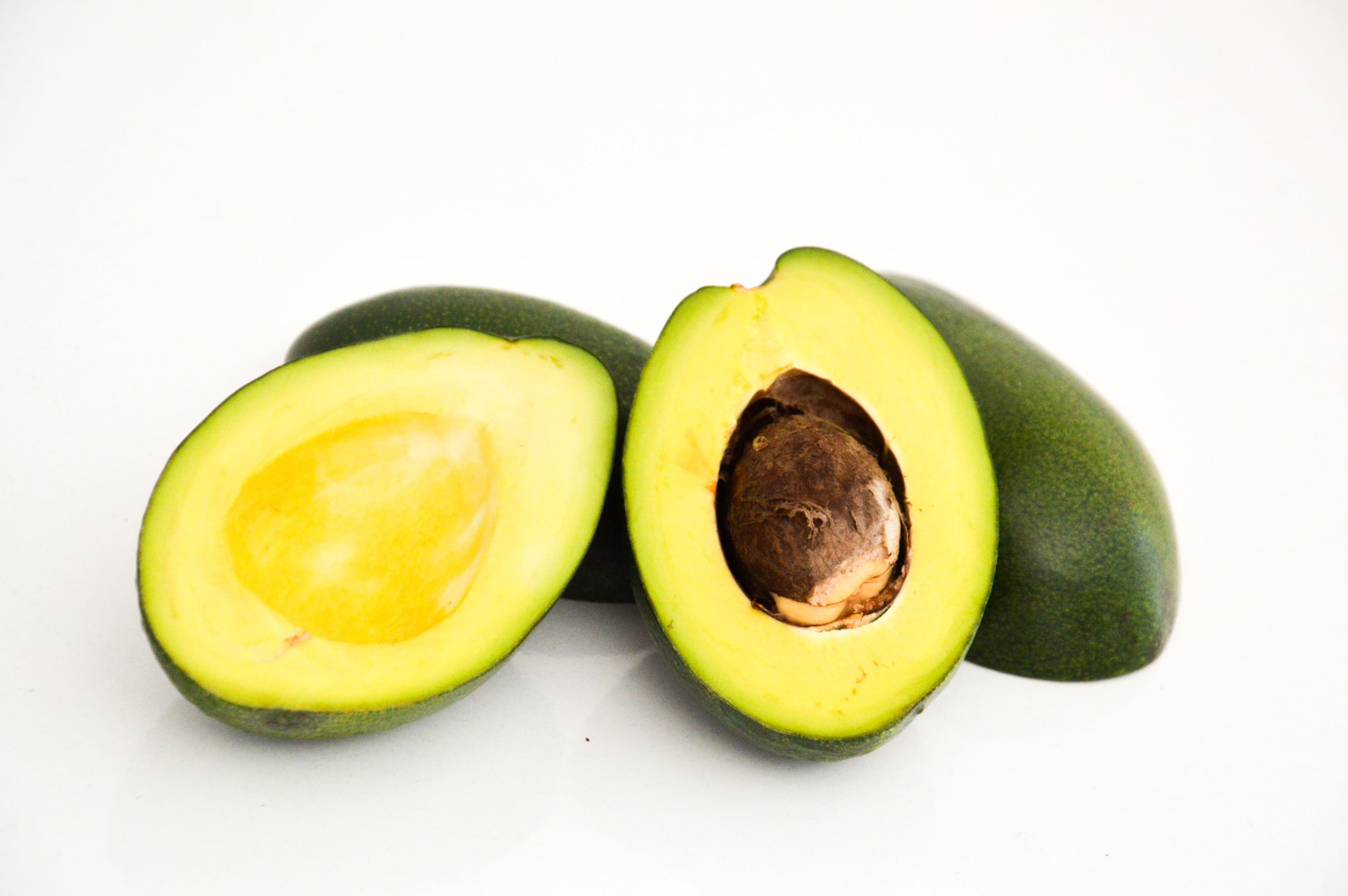 A halved avocado with dark-green skin