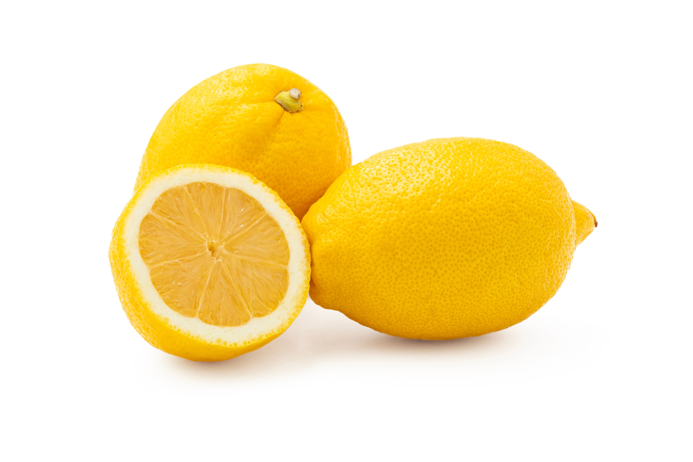 A whole lemon and a halved lemon on a white background