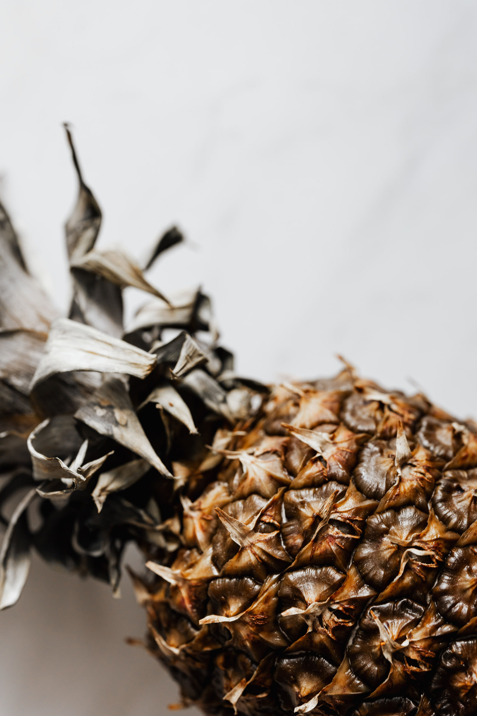 A ripe pineapple with rough skin and green leaves