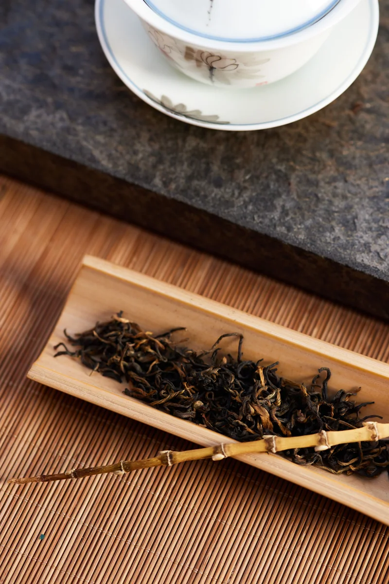 Dry tea leaves and a teacup