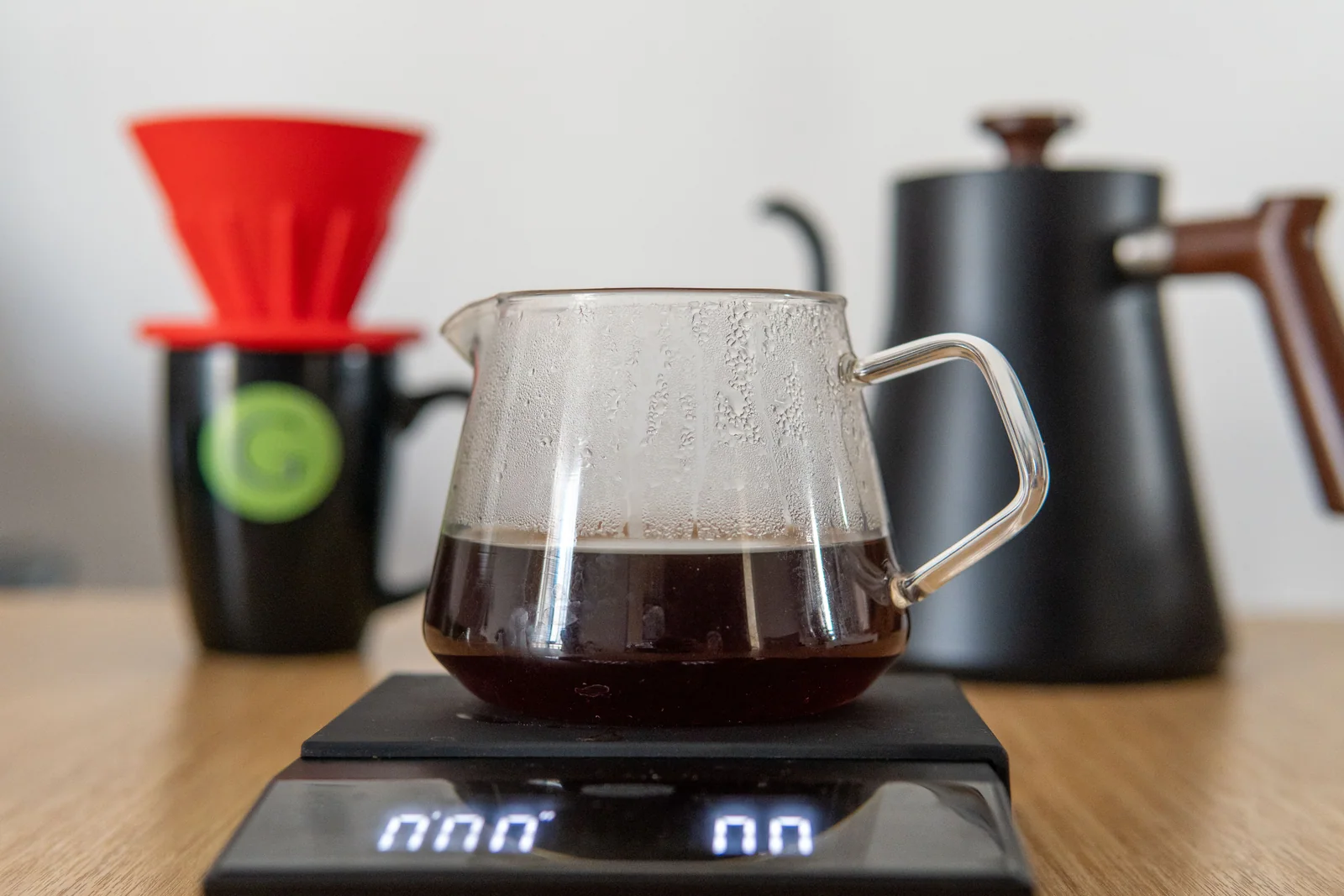 A pour-over setup with a dripper, server, scale and kettle