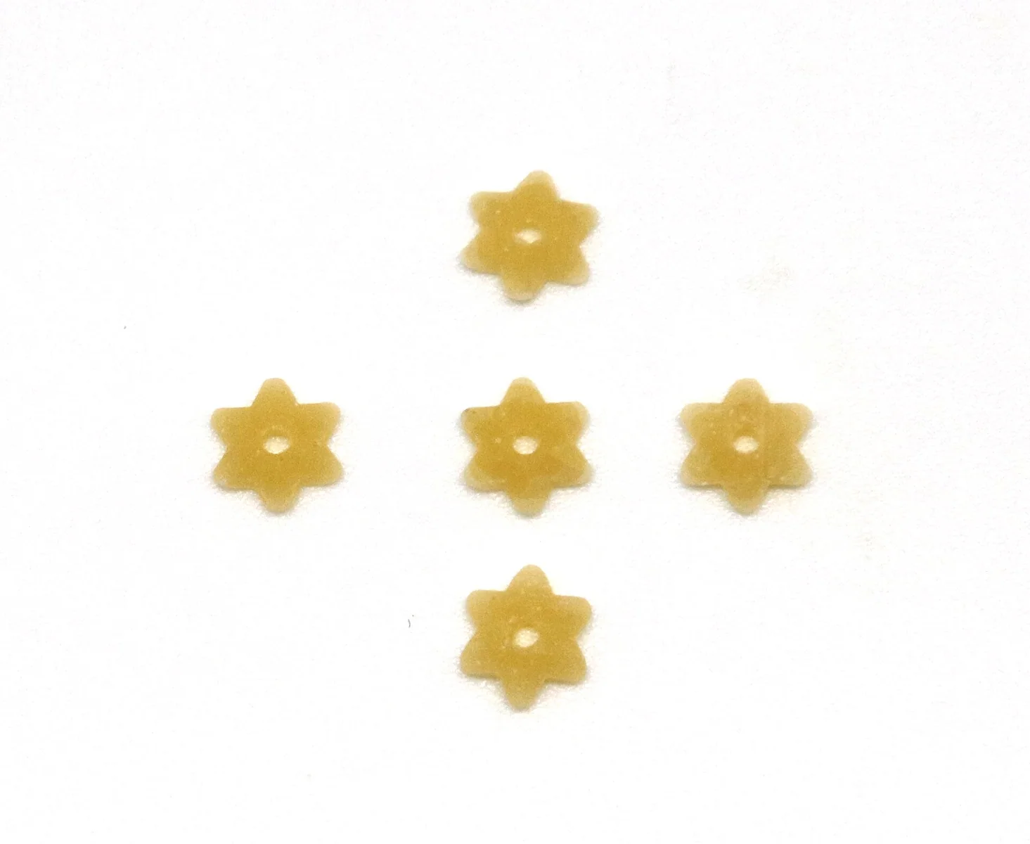 Tiny star-shaped dried stelline with holes in the center