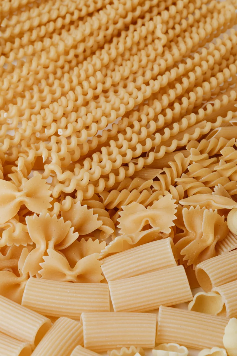 A photograph of assorted dried pasta, including spirals, ribbons and tubes