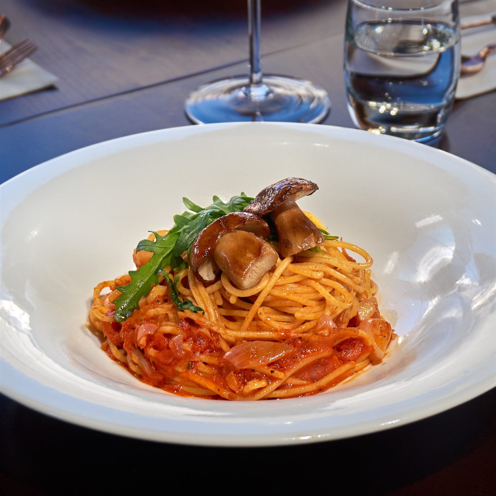 Spaghetti in tomato sauce with shallot and roasted porcini