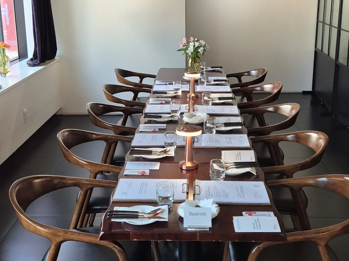A long reserved table set with menus and cutlery at Mahina Vegan Table